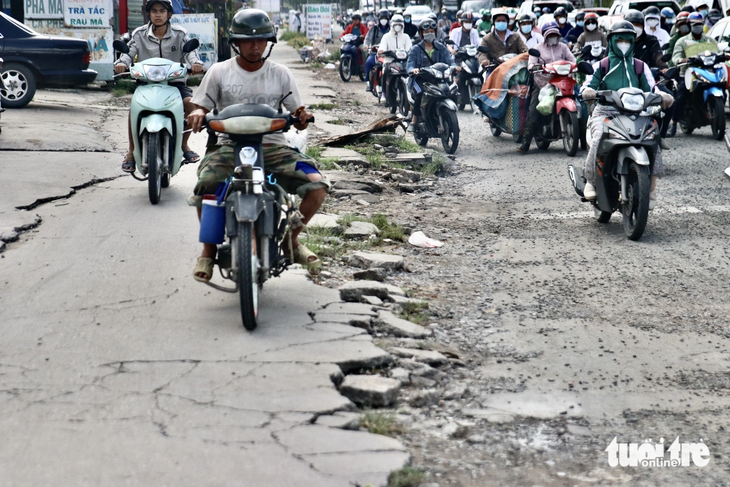 Vỉa hè bong tróc, vỡ vụn, còn người dân thì thường xuyên leo lề vào giờ cao điểm - Ảnh: TIẾN QUỐC