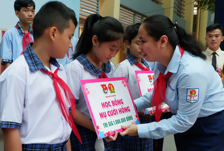 Chị Trịnh Thị Hiền Trân, phó bí thư Thành Đoàn TP.HCM, chủ tịch Hội đồng Đội thành phố, trao học bổng cho các em học sinh có hoàn cảnh khó khăn - Ảnh: K.ANH