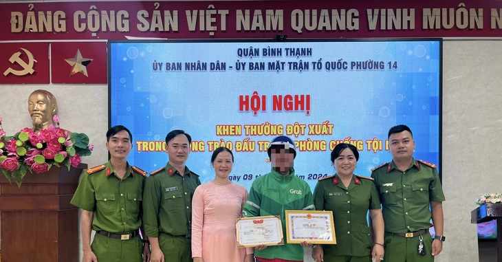 Anh T.N.T. (tài xế xe ôm công nghệ, giữa) được khen thưởng vì góp phần phát hiện kịp thời một vụ mua bán ma túy - Ảnh: Q.BT.