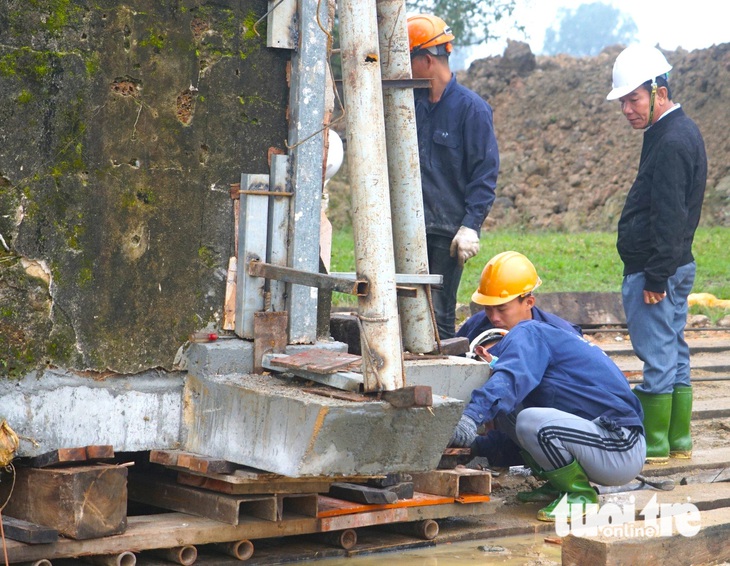 Các kỹ sư và công nhân trong quá trình di chuyển cổng đền - Ảnh: LÊ MINH