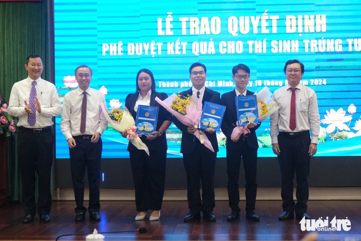 3 thí sinh xuất sắc trúng tuyển công chức, viên chức và sẵn sàng nhận nhiệm vụ mới (ôm hoa, từ trái qua: Nguyễn Thị Huỳnh Như, Trần Quang Anh, Lưu Văn Khoa) - Ảnh: NGỌC PHƯỢNG