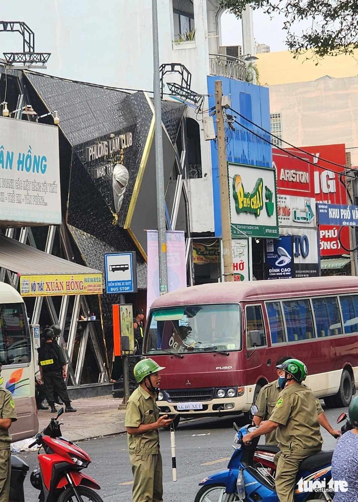 Đến 14h30 cùng ngày, lực lượng chức năng vẫn phong tỏa đoạn đường phía trước quán bar. Lực lượng cảnh sát cơ động đang túc trực phía trước cửa quán bar - Ảnh: NGỌC KHẢI