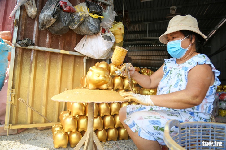 Cô Thu Sương (chủ cơ sở heo Thu Sương) chia sẻ nghề làm heo đất là do ông bà để lại nên sẽ còn làm hoài để gìn giữ nghề gia đình và mang không khí Tết đến cho mọi người thông qua sản phẩm mình làm ra - Ảnh: P.Q