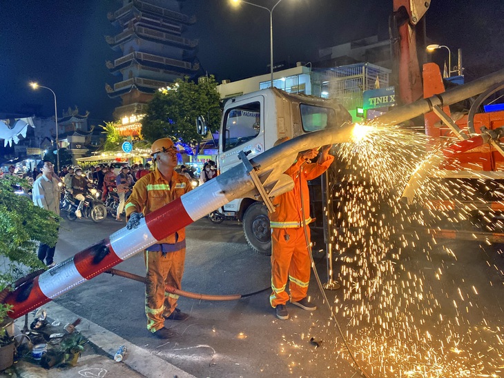 Đến khoảng 22h, nhân viên Công ty Công trình cầu phà TP.HCM bắt đầu tháo dỡ khung giới hạn để xe cộ được đi lại - Ảnh: TIẾN QUỐC