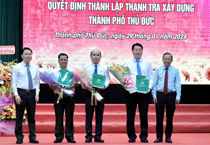 Giám đốc Sở Xây dựng TP.HCM (trái) cùng Bí thư Thành ủy Thủ Đức (phải) trao quyết định bổ nhiệm 3 nhân sự - Ảnh: CẨM NƯƠNG