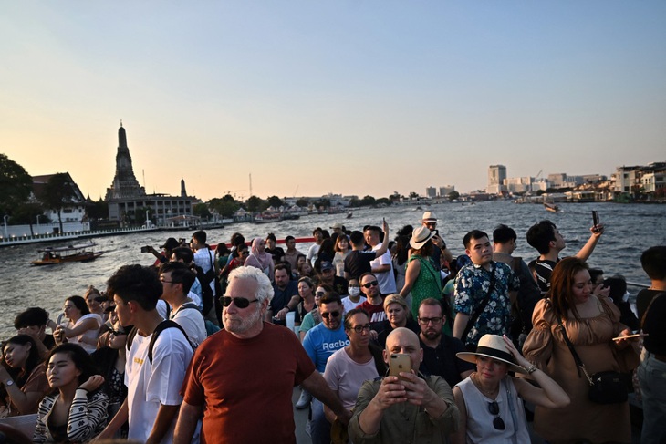 Khách du lịch và dân địa phương ngắm cảnh từ tàu du lịch trên sông Chao Phraya ở Bangkok (Thái Lan) vào ngày 27-12-2023 -  Ảnh: AFP