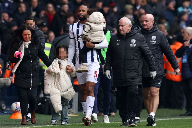 Kyle Bartley dẫn các thành viên trong gia đình rời khỏi đám đông - Ảnh: DAILY MAIL