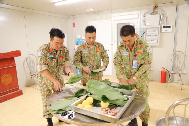 Đôi tay của các sĩ quan công binh Việt Nam thuần thục gói bánh chưng ngày Tết - Ảnh: Đội công binh Việt Nam