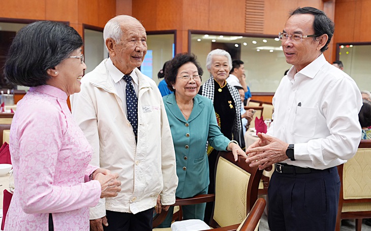 Bí thư Thành ủy TP.HCM Nguyễn Văn Nên trao đổi cùng một số cán bộ lão thành cùng dự hội nghị sáng 30-1 - Ảnh: HỮU HẠNH