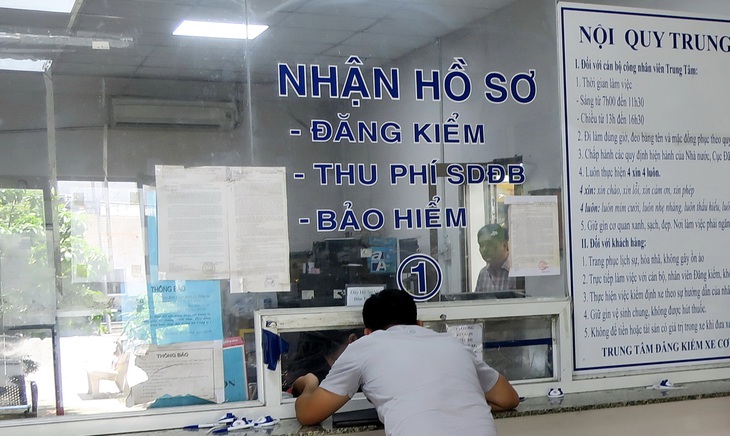 Người dân đóng phí đường bộ trong trạm đăng kiểm tại TP.HCM - Ảnh: T.T.D.