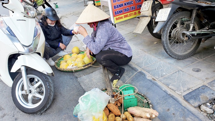 Bà Hường cố bán hết gánh khoai, bưởi để sang thăm con gái trọ xa nhà - Ảnh: TÂM LÊ