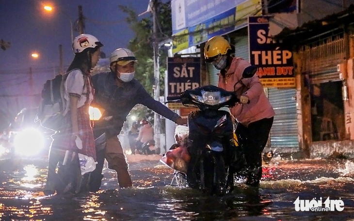 Đi học, đi làm về trễ còn gặp triều cường, người dân chật vật trên đường - Ảnh 1.