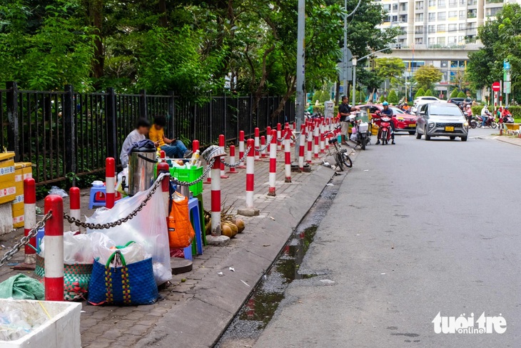 Rào chắn vỉa hè quanh tòa nhà ngăn hàng rong, hàng rong vẫn bán, người đi bộ phải xuống lòng đường - Ảnh 2.