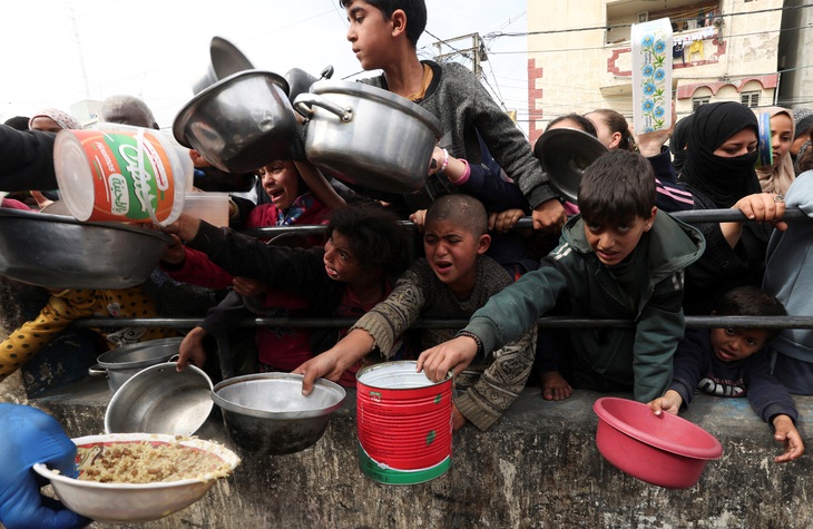 Trẻ em Palestine chờ nhận thức ăn tại một nhà bếp từ thiện trong bối cảnh thiếu nguồn cung cấp thực phẩm tại Rafah, phía nam Dải Gaza, ngày 13-2 - Ảnh: Reuters