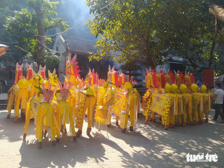 Trước sân đền, hàng chục con ngựa giấy đã được người dân vận chuyển vào đặt ngay ngắn. Cạnh đó lò thiêu luôn cháy không ngừng bởi liên tục có người đốt vàng mã, ngựa giấy - Ảnh: LÊ MINH