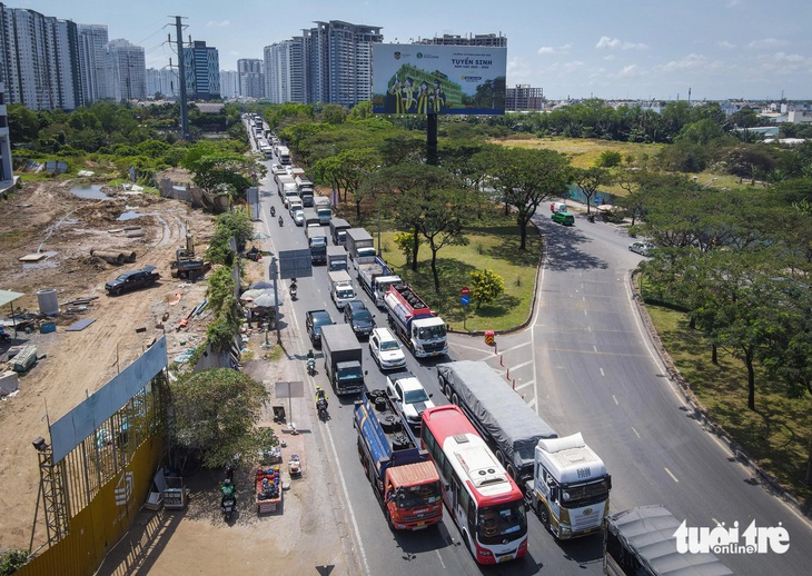 Hàng dài xe ô tô, xe tải nối đuôi nhau trên đường Nguyễn Hữu Thọ (hướng ra nút giao Nguyễn Văn Linh, quận 7, TP.HCM) - Ảnh: CHÂU TUẤN