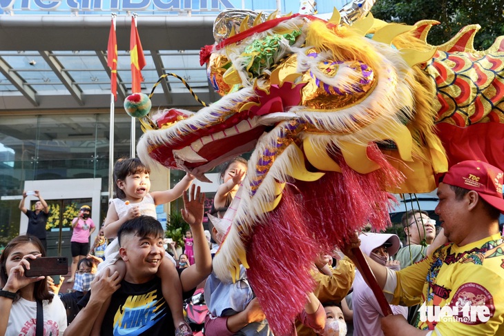 Người dân thích thú xem diễn lân sư rồng trong chương trình diễu hành nghệ thuật đường phố