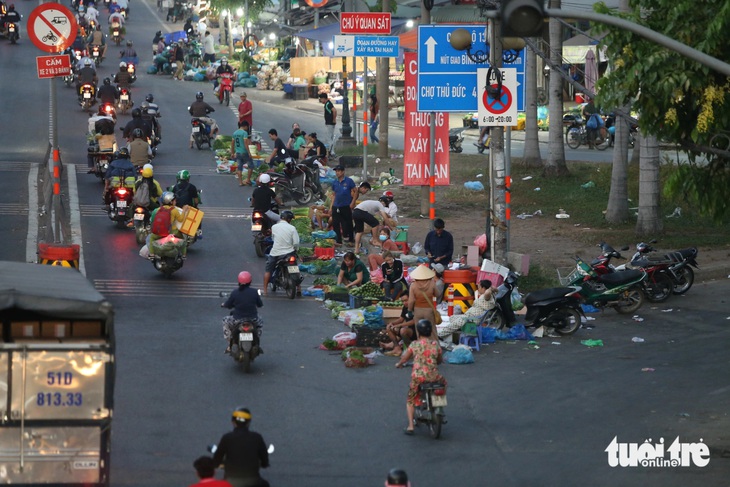 Nhiều người dân lấn chiếm lòng đường quốc lộ 1, bày bán rau củ quả... tiềm ẩn nguy cơ tai nạn