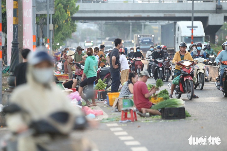 Không chỉ lấn chiếm vỉa hè, nhiều người còn bày bán thực phẩm dưới lòng đường, đoạn trước chợ đầu mối Thủ Đức 