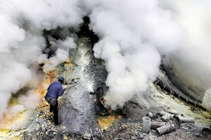 Một thợ mỏ đang khai thác lưu huỳnh tại núi lửa Kawah Ijen - Ảnh: LARRY LOUIE