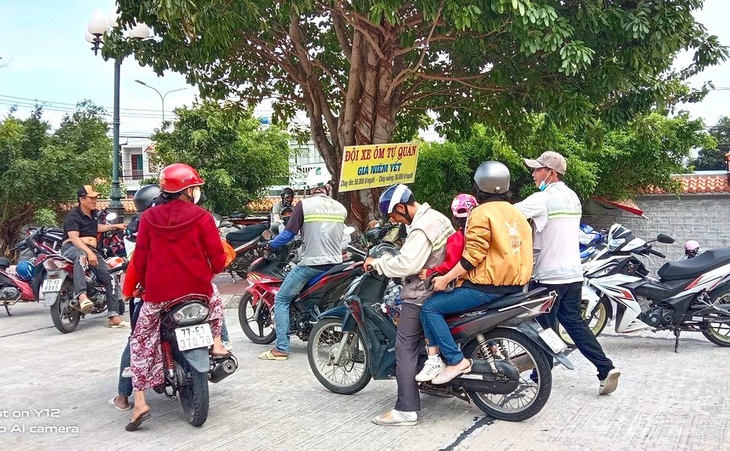 Các tài xế xe ôm tại chùa Ông Núi đội mũ bảo hiểm cho mình và du khách, sau khi báo Tuổi Trẻ phản ánh tình trạng vụ việc - Ảnh: N.V.H.