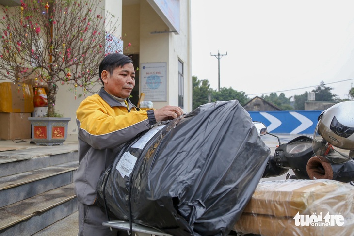 Ông Đoàn Văn Hùng cẩn thận kiểm tra từng đơn hàng và tính lộ trình trong đầu trước khi đi giao cho khách - Ảnh: HÀ QUÂN