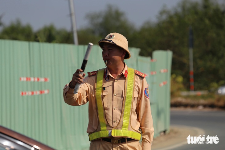 Lực lượng Cục Cảnh sát giao thông phân luồng xe vào cao tốc TP.HCM - Long Thành - Dầu Giây, đảm bảo thông tuyến để người dân yên tâm về quê đón Tết - Ảnh: MINH HÒA