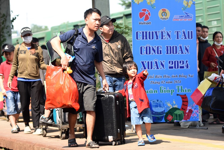 Một gia đình tay xách nách mang hành lý háo hức ra khu vực chờ lên tàu về quê đón Tết - Ảnh: A LỘC