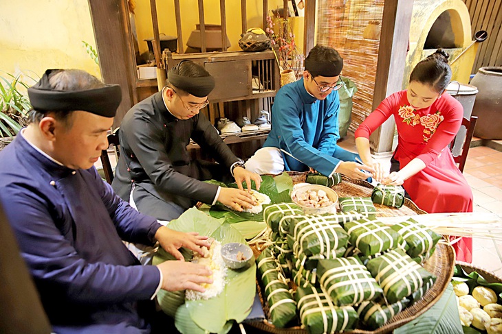 Gia đình cùng gói bánh chưng là nét đẹp ngày Tết được giữ gìn - Ảnh: VŨ TÀI