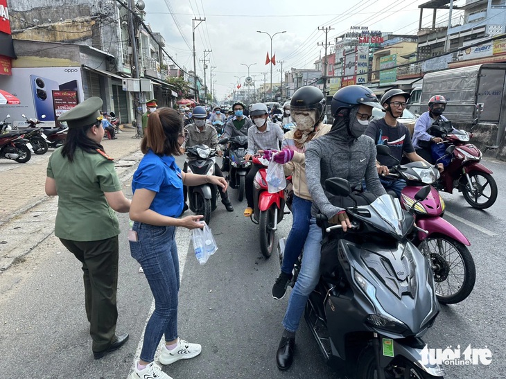 Các bạn đoàn viên thanh niên xuống đường chung tay phát nước suối, khăn lạnh cho người dân - Ảnh: HOÀI THƯƠNG