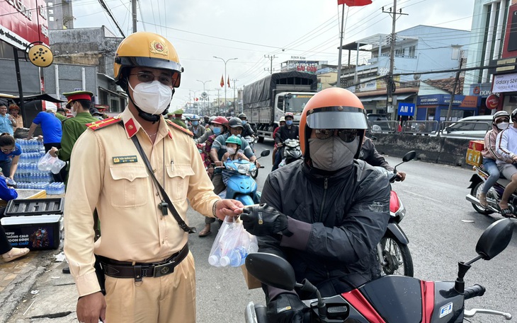 Cảnh sát giao thông phát nước, khăn lạnh miễn phí cho người dân về quê ăn Tết