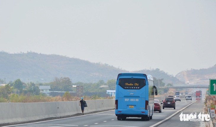 Một người đàn ông đi giữa cao tốc Phan Thiết - Dầu Giây để nhặt ve chai tại Km38+400 - Ảnh: ĐỨC TRONG