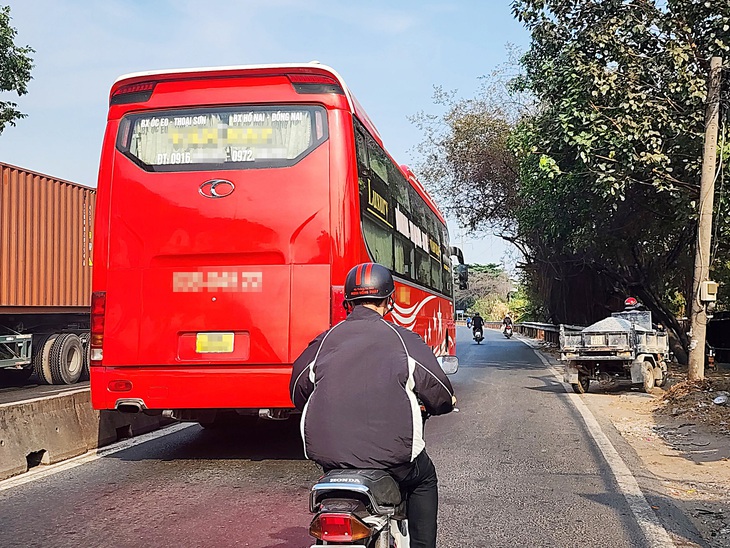 Xe khách chạy lấn vào làn xe máy trên quốc lộ 1, đoạn qua phường Linh Trung, TP Thủ Đức. Nhiều người đi xe máy sợ va chạm với xe khách phải né ra để xe này chạy - Ảnh: MINH HÒA