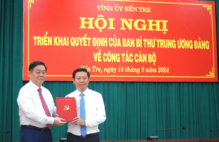 Ông Nguyễn Trọng Nghĩa, bí thư Trung ương Đảng, trưởng Ban Tuyên giáo Trung ương, trao quyết định nhận nhiệm vụ mới cho ông Trần Thanh Lâm - phó bí thư Tỉnh ủy Bến Tre - Ảnh: MẬU TRƯỜNG