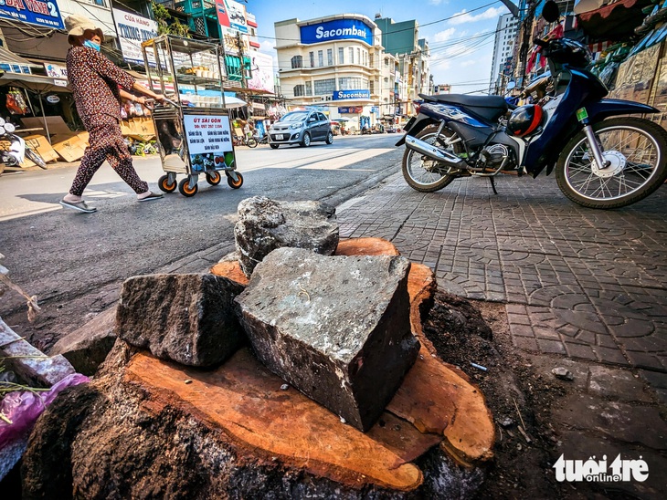 Hàng cổ thụ trên đường Hoàng Văn Thụ ở phố núi Pleiku bị cưa sát gốc- Ảnh 5. Người phụ nữ bán đồ ăn dạo đẩy xe hàng đi qua đường Hoàng Văn Thụ - Ảnh: TẤN LỰC