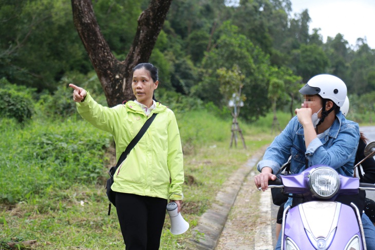 Chị Tuyết (trái) nhắc nhở du khách không cho khỉ ăn khi lên tham quan bán đảo Sơn Trà - Ảnh: ĐOÀN NHẠN