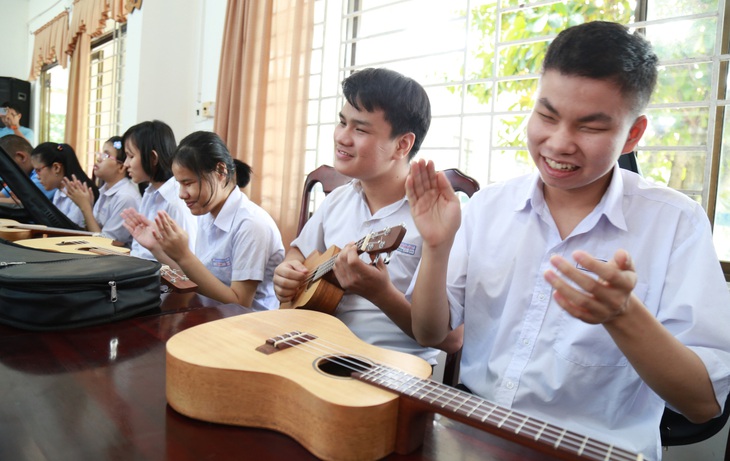 Các em nhỏ khiếm thị háo hức với chiếc đàn ukulele - Ảnh: ĐOÀN NHẠN