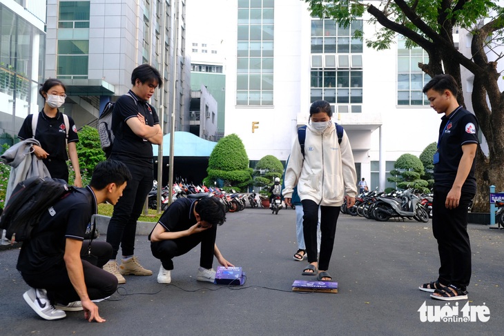 Nhóm sinh viên thử nghiệm sáng chế thu điện từ bước chân ngay tại Trường đại học Công nghiệp TP.HCM - Ảnh: NGỌC PHƯỢNG