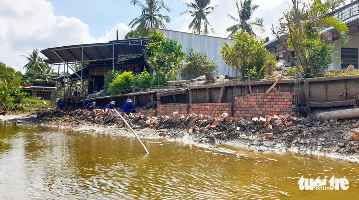 Tranh thủ nước cạn, người dân xuống sông xây dựng bờ kè chống sạt lở