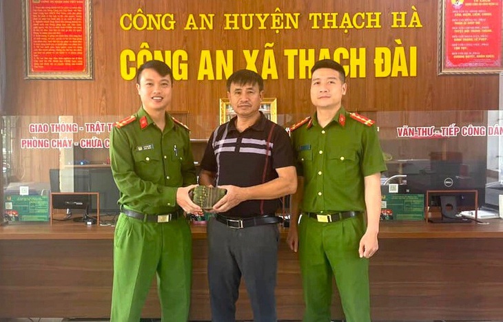 Ông Thông (giữa) nhận lại số tiền 100 triệu đồng bị đánh rơi - Ảnh: H.A.