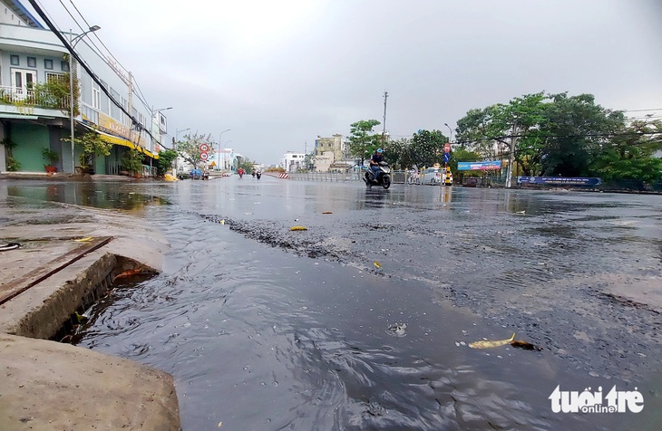 Mưa to khiến nước đổ về các miệng cống ven đường, chảy ra biển - Ảnh: CHÍ CÔNG