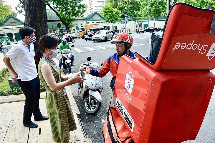 Từ chuyện Shopee hoàn tiền lên đến 15 ngày- Ảnh 1. Shipper của Shopee giao hàng cho khách ở quận 1, TP.HCM - Ảnh: QUANG ĐỊNH