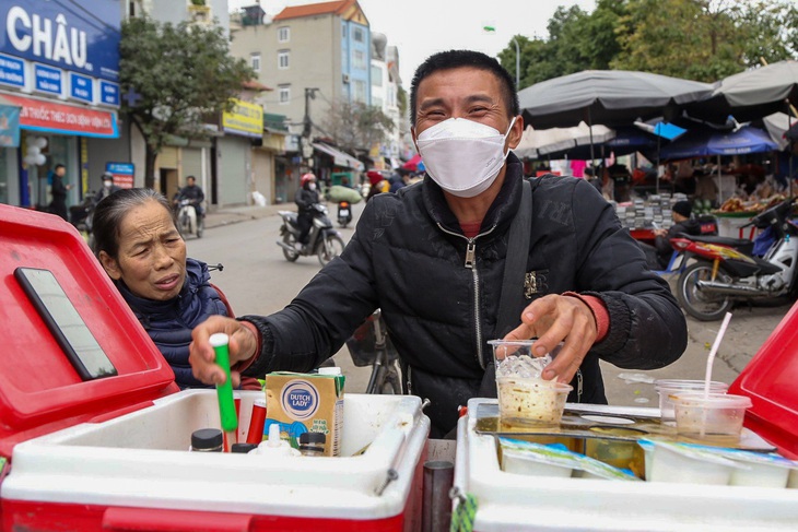 Tiệm cà phê dạo của anh Nguyễn Văn Hay thực chất là thùng đựng cà phê pha sẵn, đá viên, khay pha chế với chồng cốc nhựa trên chiếc xe Honda Dream cũ. Trước đầu xe, anh treo lủng lẳng vài chiếc túi đựng chai nhựa rỗng - Ảnh: HÀ QUÂN