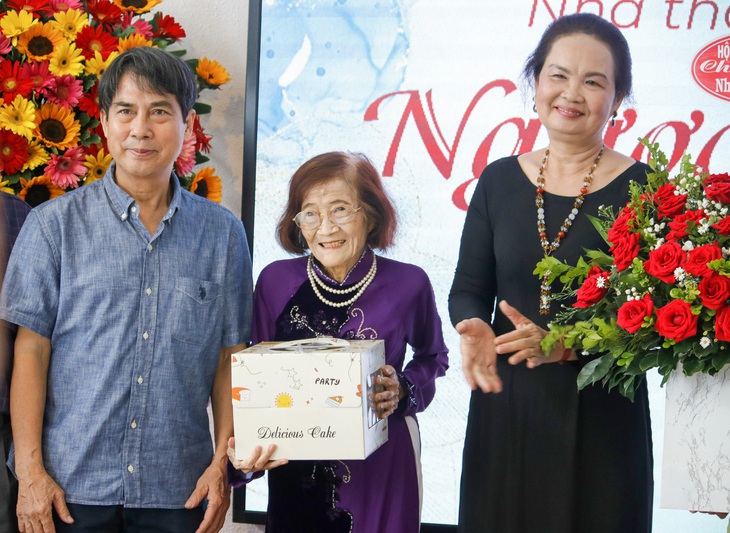 Nhà giáo Phạm Như Vân 85 tuổi vẫn thương thơ mến văn- Ảnh 1. Nhà thơ Phạm Như Vân (giữa) nhận bánh kem đón sinh nhật tuổi 85 từ kiến trúc sư Nguyễn Trường Lưu (bìa trái) và chủ tịch Hội Nhà văn TP.HCM Trịch Bích Ngân (bìa phải) - Ảnh: HỒ LAM