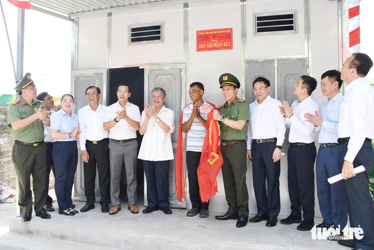 Thượng tướng Lương Tam Quang, thứ trưởng Bộ Công an (thứ 5 từ phải qua), chúc mừng gia đình anh Thạch Sa Ruôl - Ảnh: HỒ GIANG