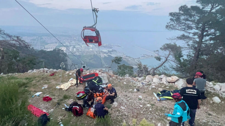 Đội cứu hộ đang giúp đỡ những người bị thương sau sự cố cáp treo - Ảnh: AFP