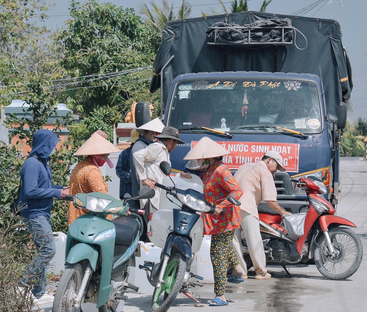 Người dân chia nhau từng thùng nước sạch - Ảnh: Facebook nhân vật