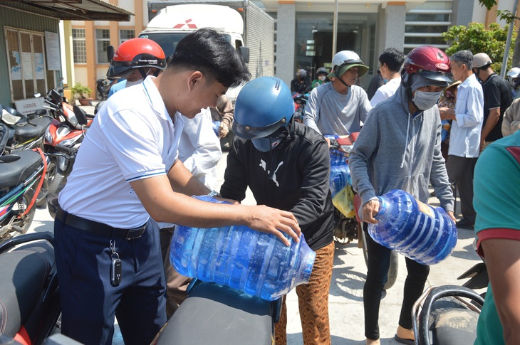 Ngoài tặng nước, nhiều đơn vị còn tặng bình, can để người dân trữ nước sử dụng lâu dài - Ảnh: MẬU TRƯỜNG