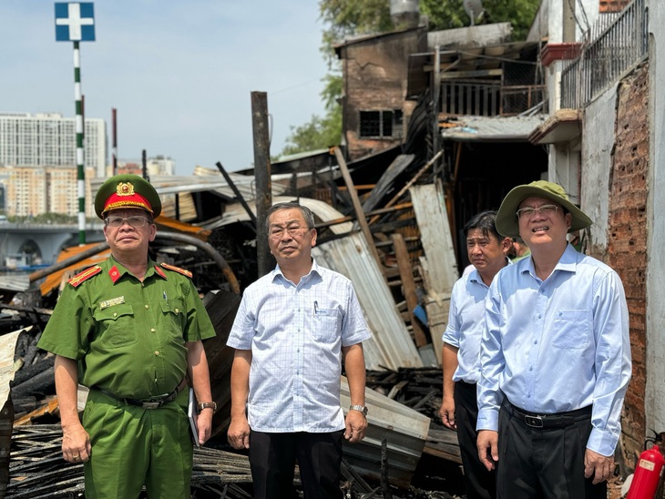 Phó bí thư thường trực Thành ủy TP.HCM Nguyễn Hồ Hải (bìa phải) và Bí thư Quận ủy quận 8 Võ Ngọc Quốc Thuận cùng các cơ quan chức năng kiểm tra hiện trường vụ cháy - Ảnh: C.T.