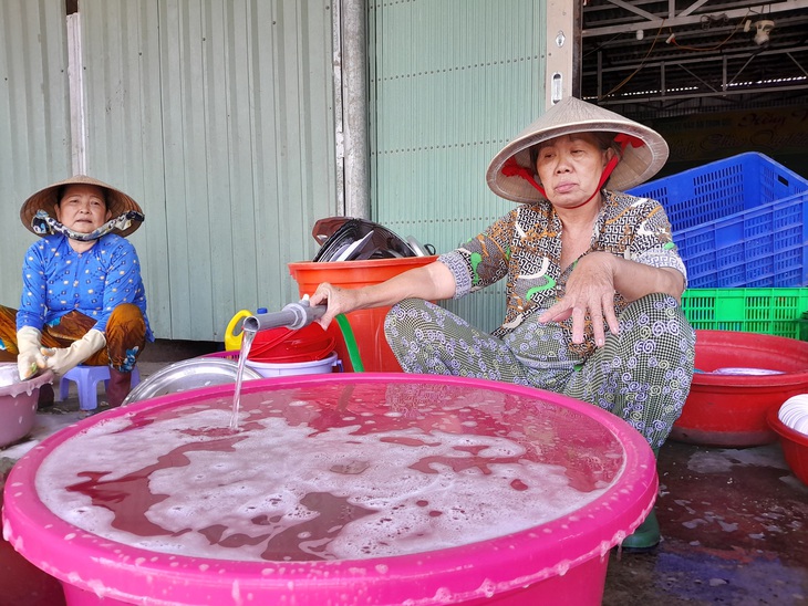 Nước chảy yếu, người dân phường Thành Phước kiên nhẫn hứng để sử dụng - Ảnh: CHÍ HẠNH